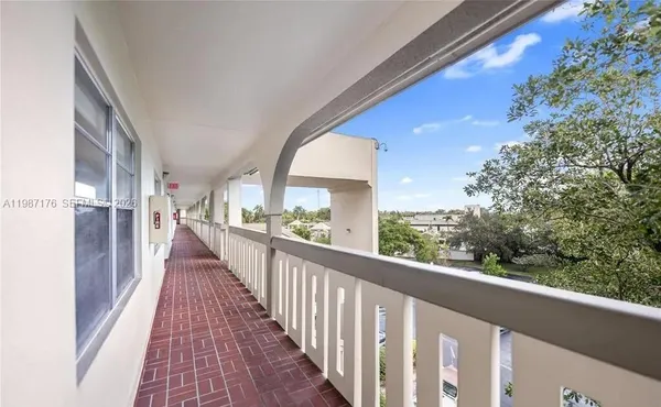 a view of a balcony with wooden floor and fence