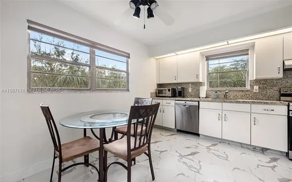 a kitchen with granite countertop a stove a table and chairs