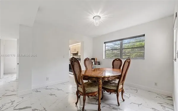 a view of a dining room with furniture a chandelier and wooden floor
