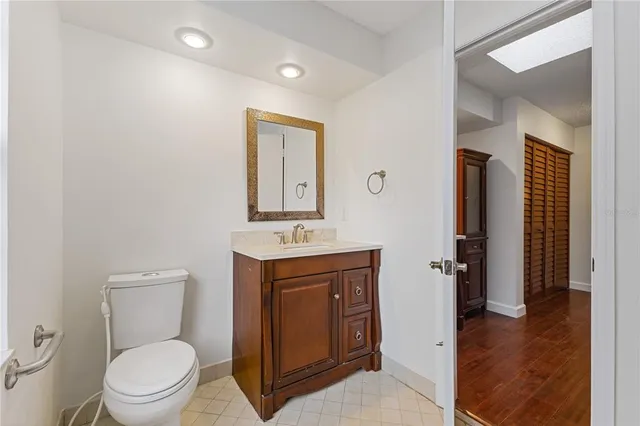 a spacious bathroom with a toilet a sink and mirror