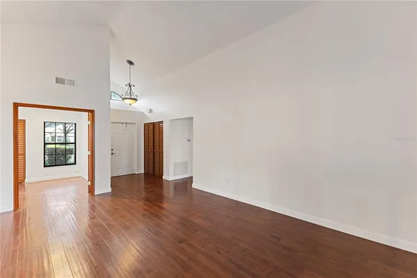 a view of an empty room with wooden floor