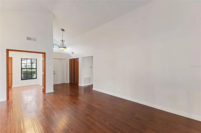 a view of an empty room with wooden floor