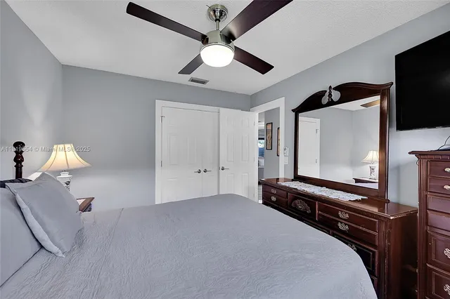 a spacious bedroom with a bed and a refrigerator