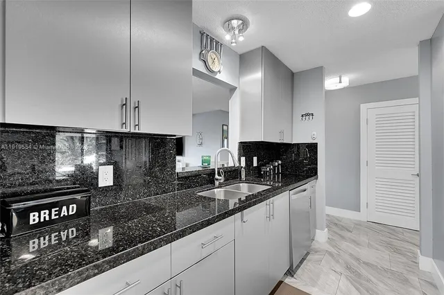 a kitchen with stainless steel appliances granite countertop a stove a refrigerator and a sink