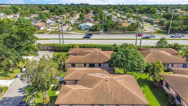 an aerial view of residential houses with outdoor space and trees all around