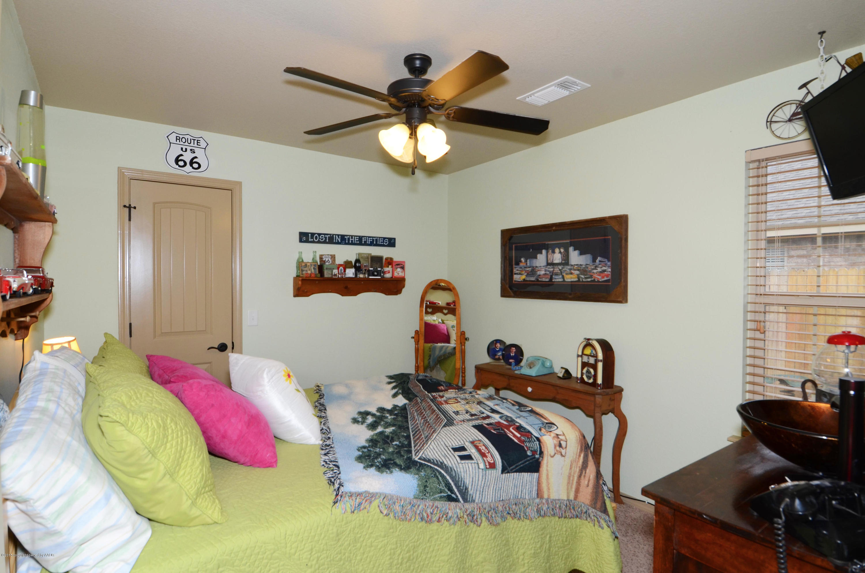 3705 Arden Road Amarillo, TX 79118 - Photo 13 of 20 a bed room with a bed mirror and a flat tv screen on a dresser