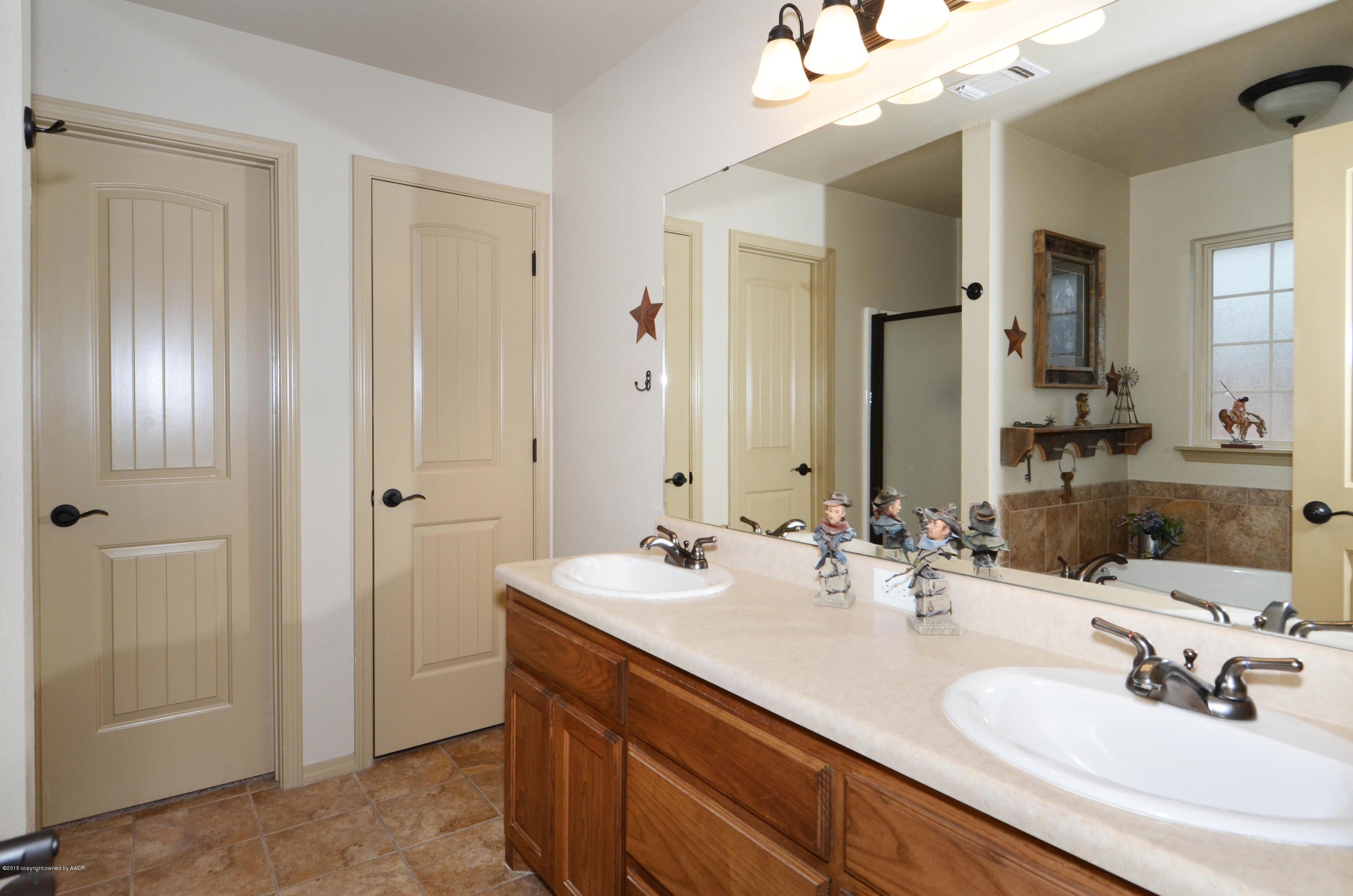 3705 Arden Road Amarillo, TX 79118 - Photo 16 of 20 a bathroom with double vanity sinks and a mirror