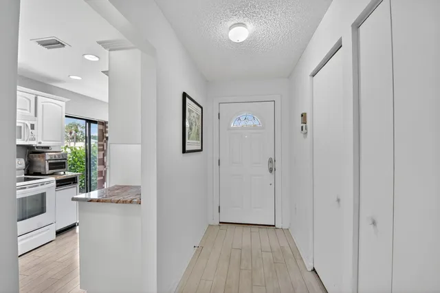 a kitchen with granite countertop white cabinets and white appliances