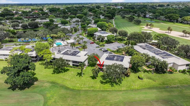 a sign of golf club on a wall under a tree