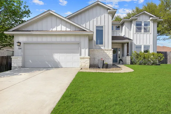 a front view of a house with a yard and garage
