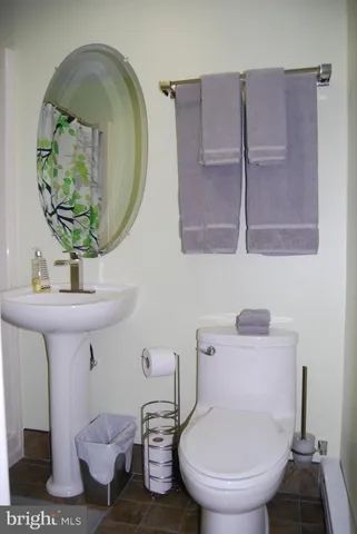 a bathroom with a toilet a sink and mirror