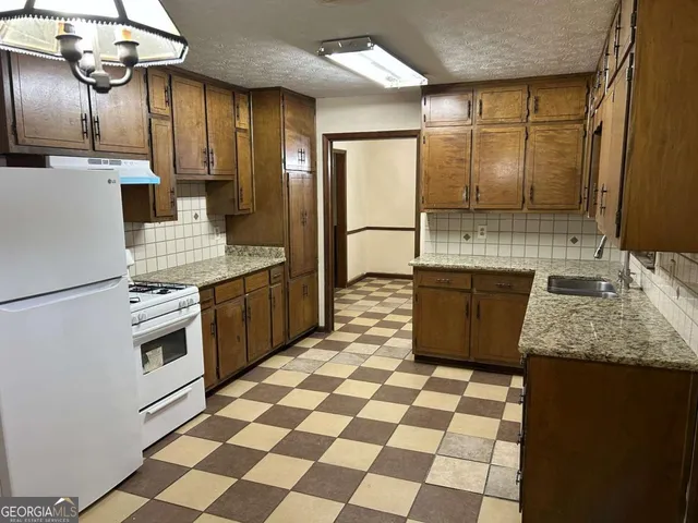 a kitchen with a sink a stove and a refrigerator