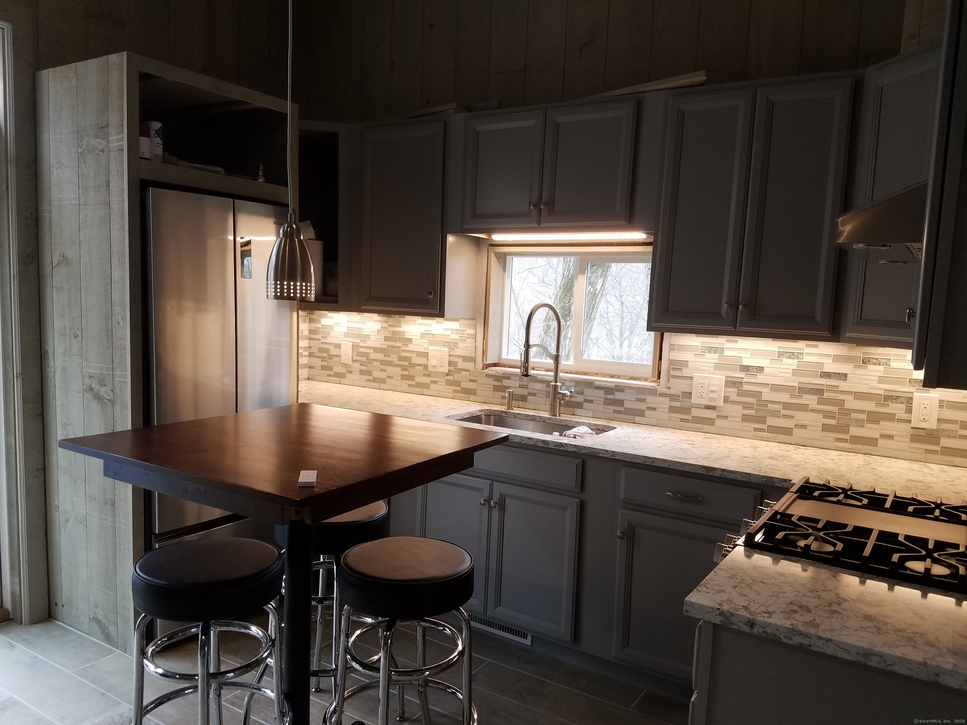 134 Nashville Road Bethel, CT 06801 - Photo 13 of 36 a kitchen with stainless steel appliances a table chairs and a refrigerator