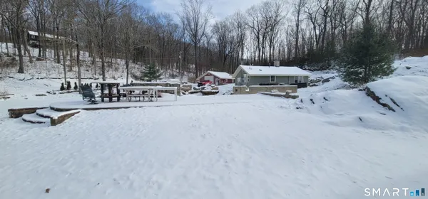 a view of backyard with a table and chairs and a barbeque
