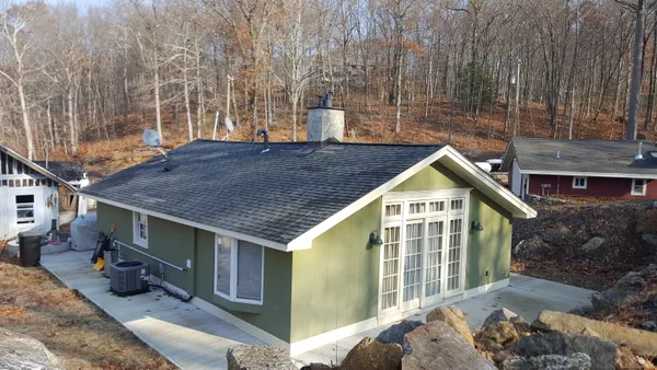 a view of a house with backyard and sitting area