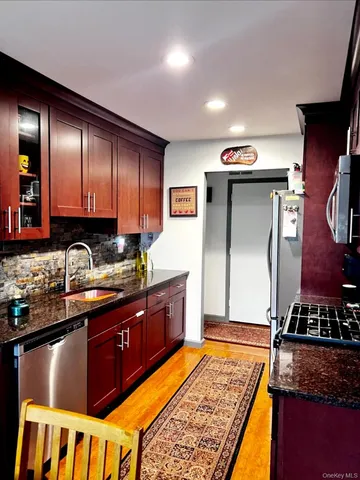 a kitchen with stainless steel appliances granite countertop a sink stove and refrigerator