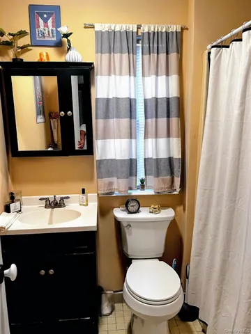 a bathroom with a toilet sink vanity and mirror