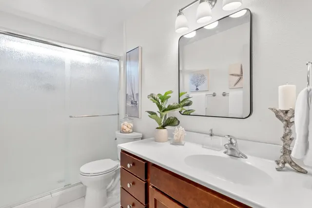 a bathroom with a sink a toilet and mirror