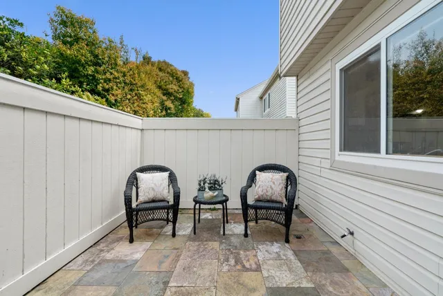 a couple of chairs sitting in balcony with window