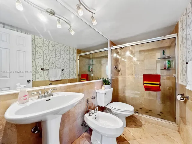 a bathroom with a sink toilet and shower