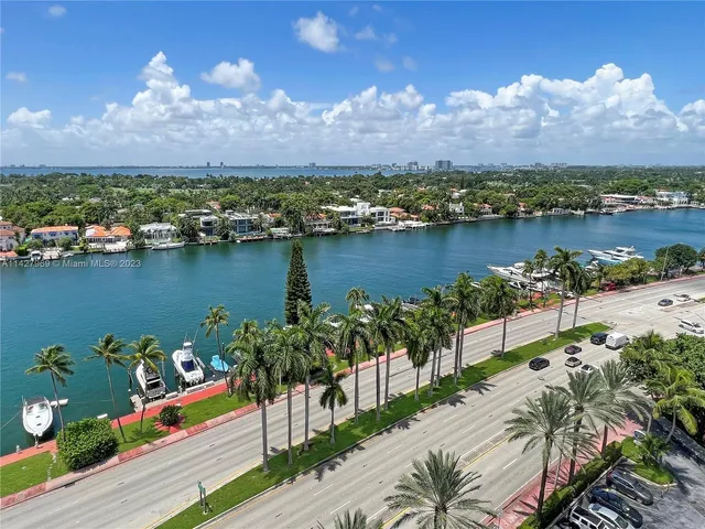 an aerial view of ocean and residential houses with outdoor space