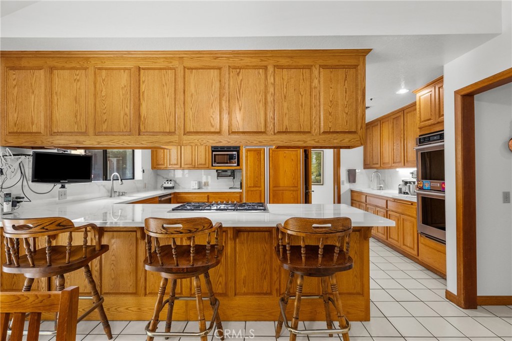52 Hidden Valley Road Monrovia, CA 91016 - Photo 18 of 55 a kitchen with stainless steel appliances granite countertop a stove top oven a sink a dining table and chairs
