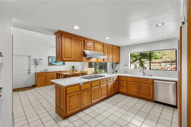 a kitchen with stainless steel appliances granite countertop a refrigerator and a stove top oven