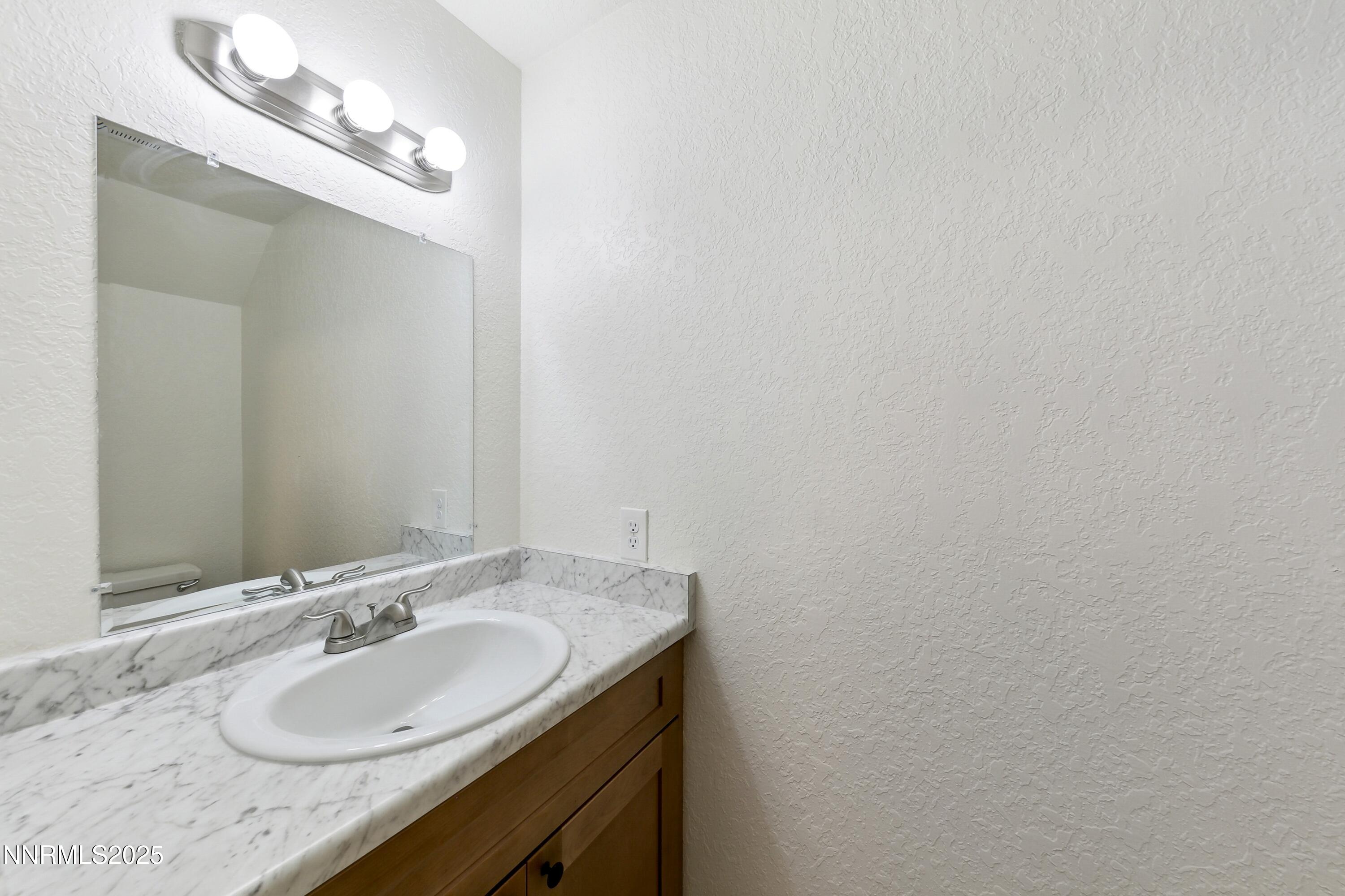 718 Travis Drive, Unit D Carson City, NV 89701 - Photo 13 of 19 a bathroom with a granite countertop sink and a mirror