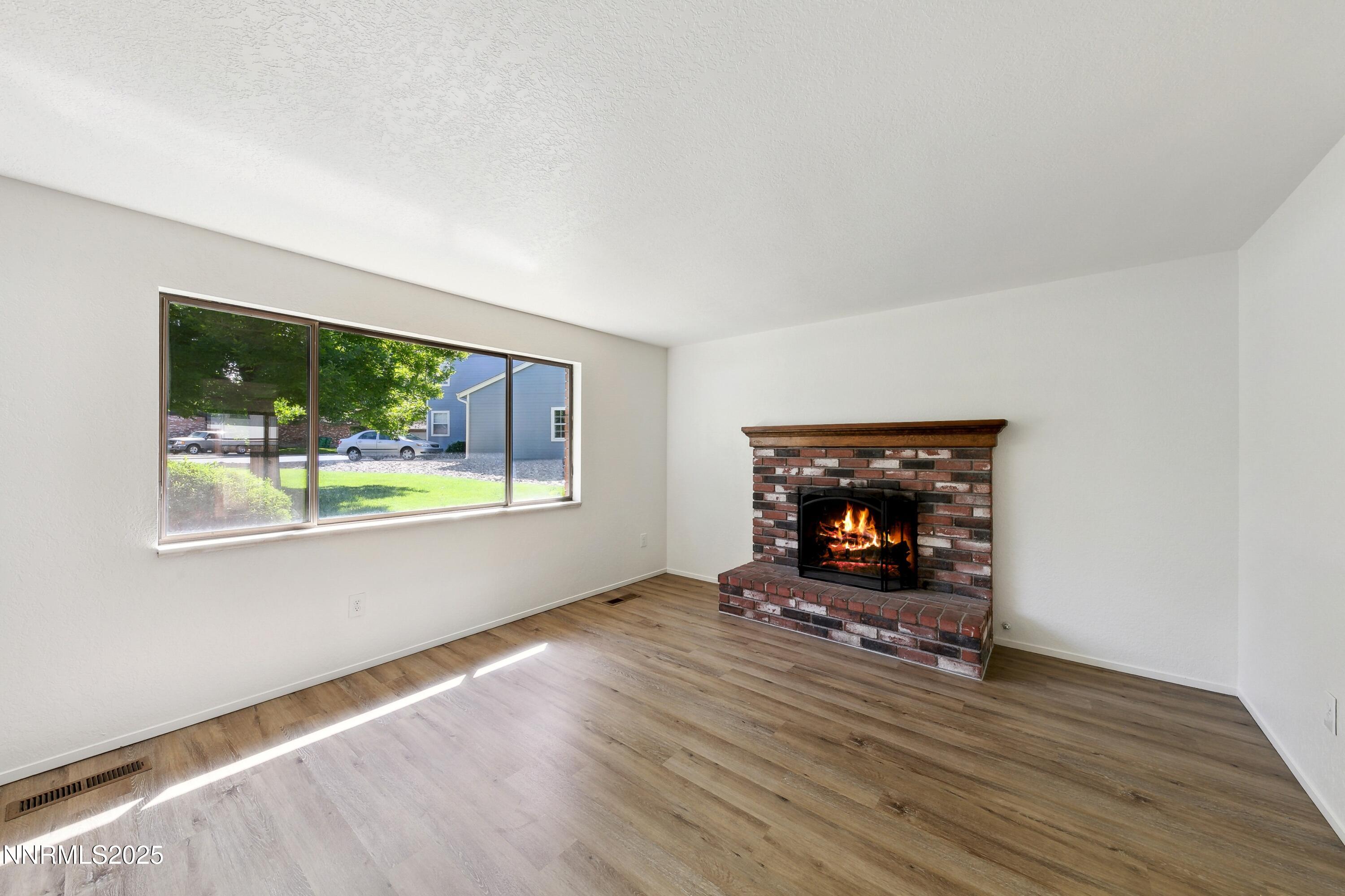 718 Travis Drive, Unit D Carson City, NV 89701 - Photo 4 of 19 a living room with fireplace and a wooden floor