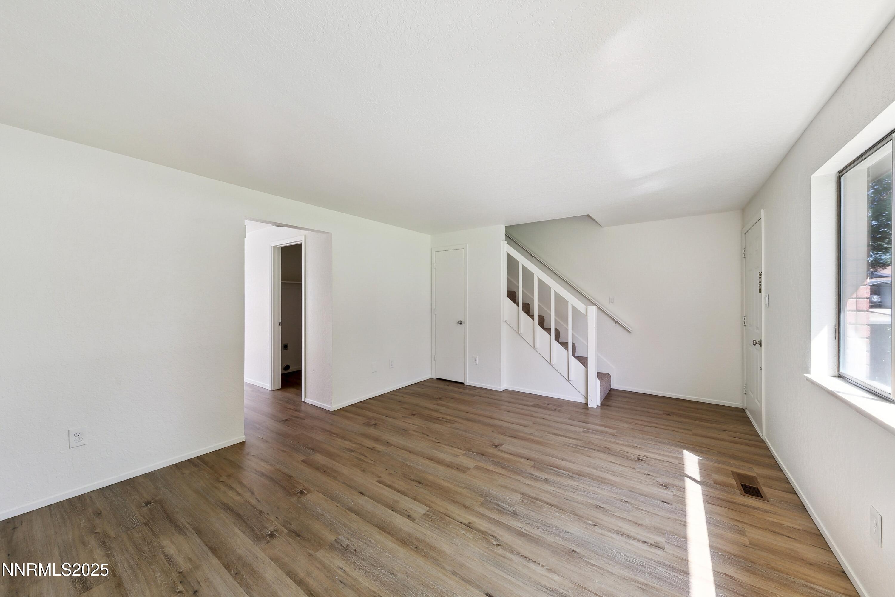 718 Travis Drive, Unit D Carson City, NV 89701 - Photo 6 of 19 a view of an empty room with wooden floor and a window
