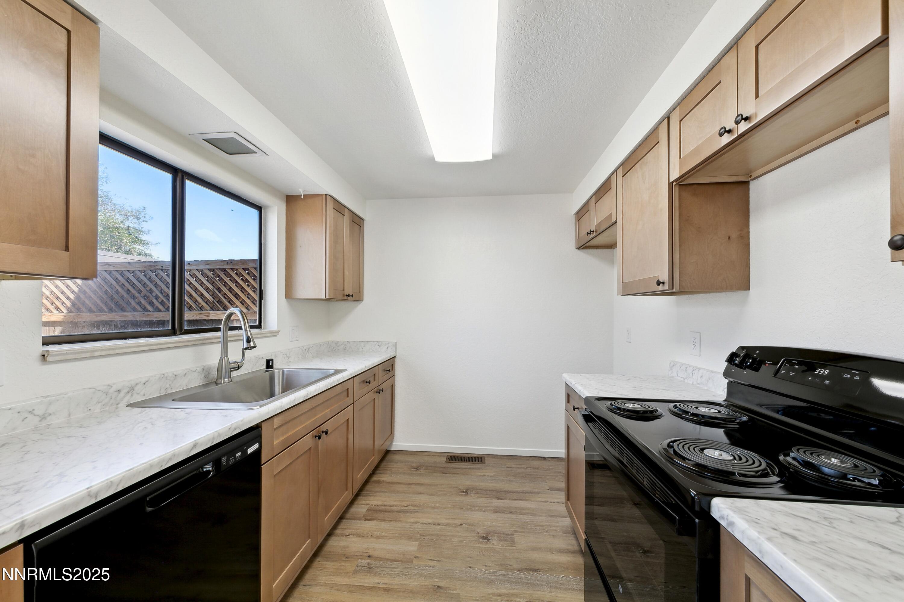 718 Travis Drive, Unit D Carson City, NV 89701 - Photo 9 of 19 a kitchen with a sink stove top oven and cabinets