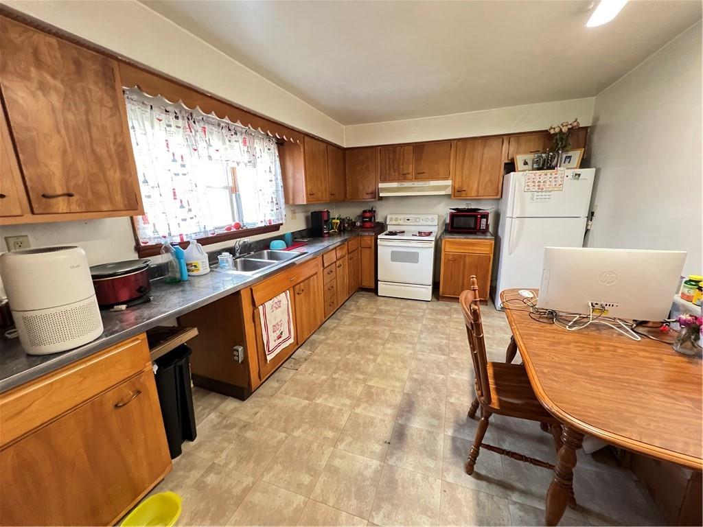 442 East Washington Street Rochester, PA 15074 - Photo 3 of 23 a kitchen with stainless steel appliances kitchen island granite countertop a table chairs sink refrigerator and cabinets