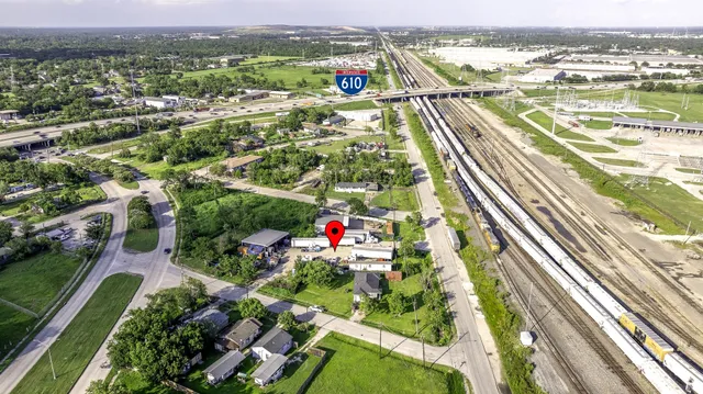 an aerial view of residential houses with outdoor space and trees