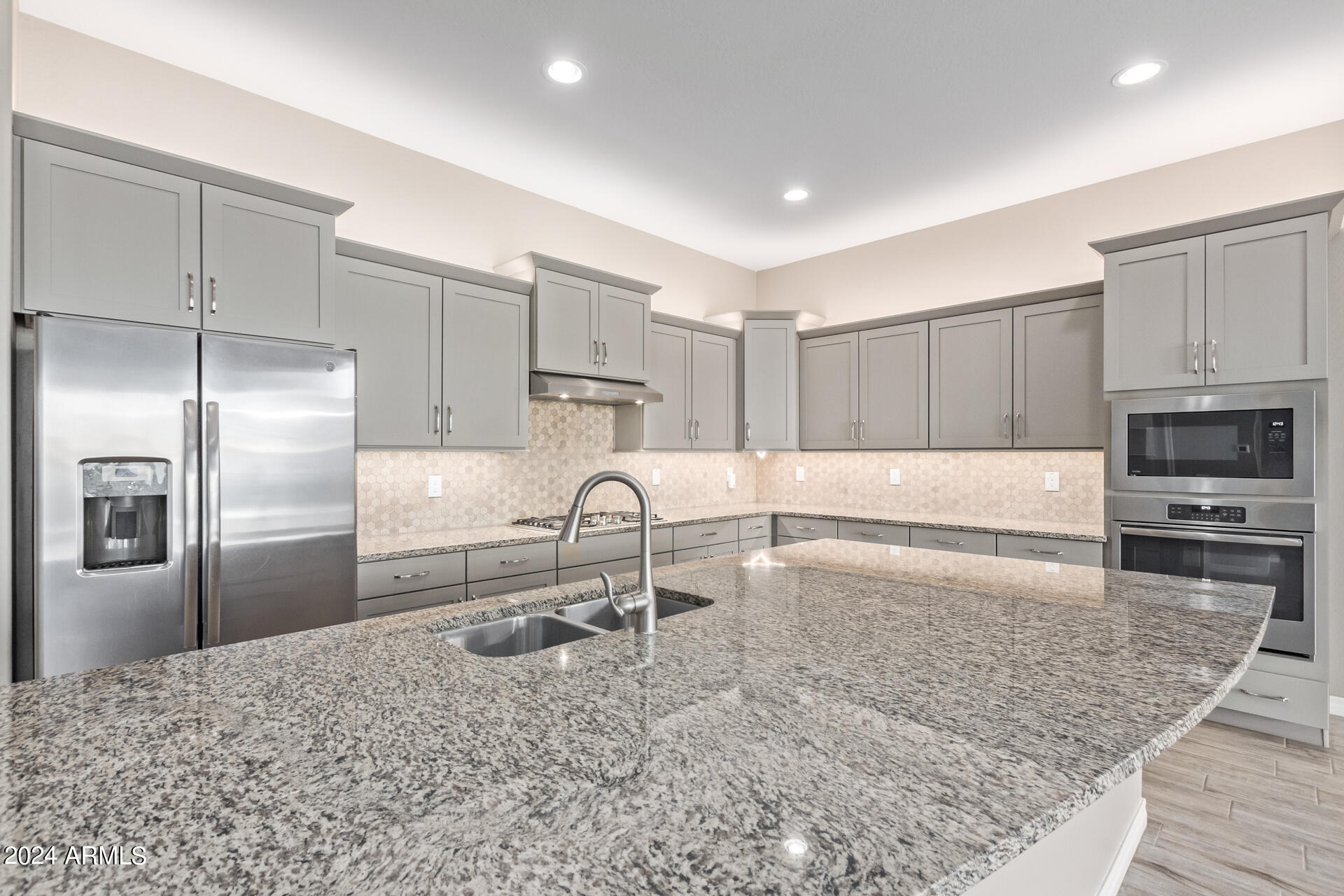 43944 Stonecreek Road Maricopa, AZ 85139 - Photo 19 of 62 a kitchen with granite countertop a refrigerator and a sink