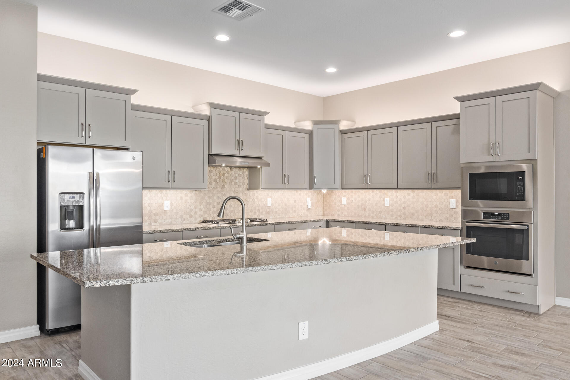 43944 Stonecreek Road Maricopa, AZ 85139 - Photo 21 of 62 a kitchen with kitchen island a counter top space stainless steel appliances and cabinets