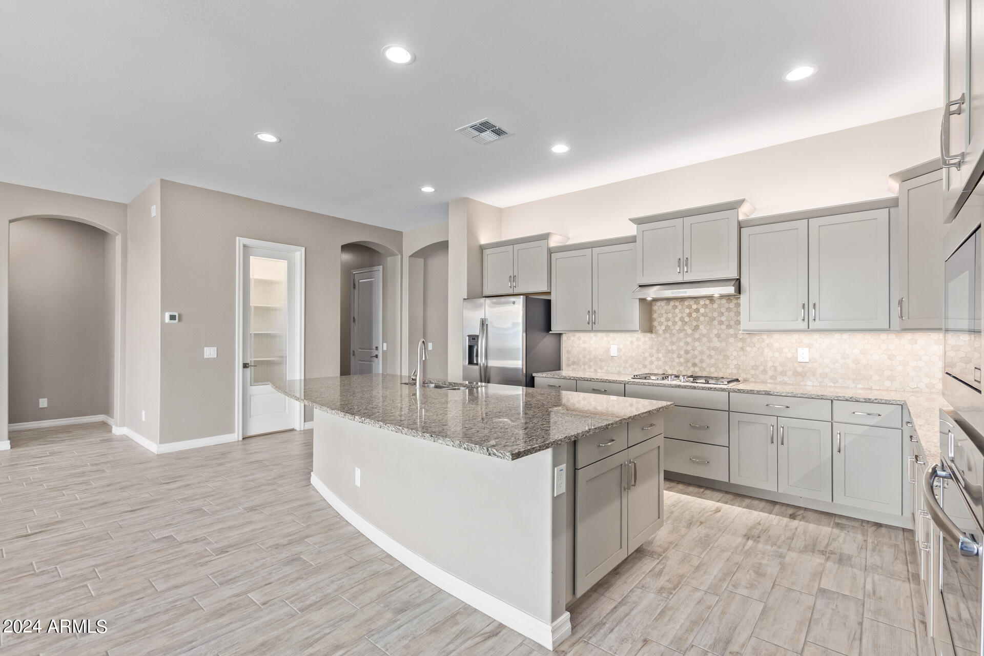 43944 Stonecreek Road Maricopa, AZ 85139 - Photo 24 of 62 a large kitchen with kitchen island a sink stainless steel appliances and cabinets