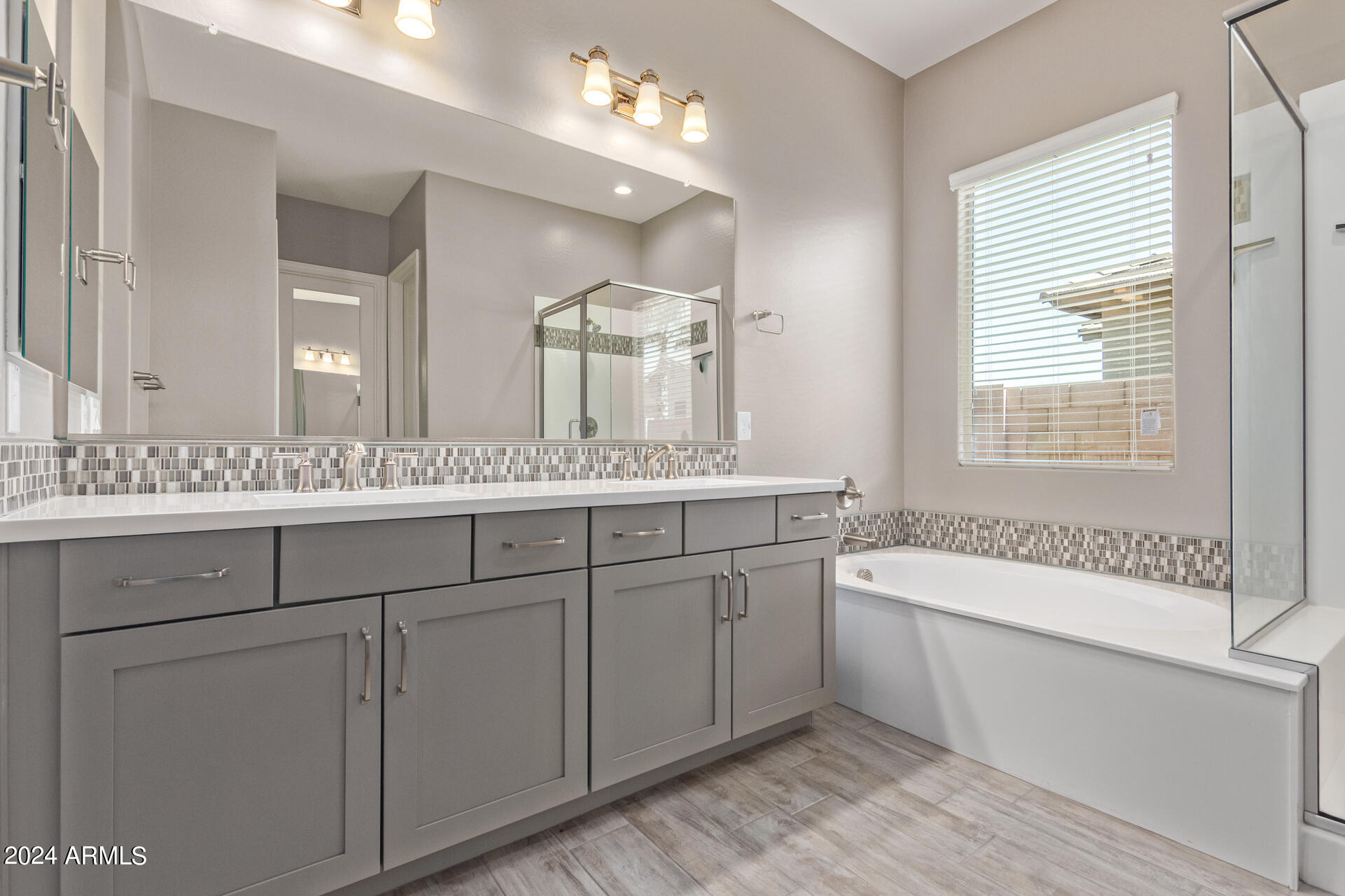 43944 Stonecreek Road Maricopa, AZ 85139 - Photo 28 of 62 a bathroom with a granite countertop sink a large mirror and a bathtub