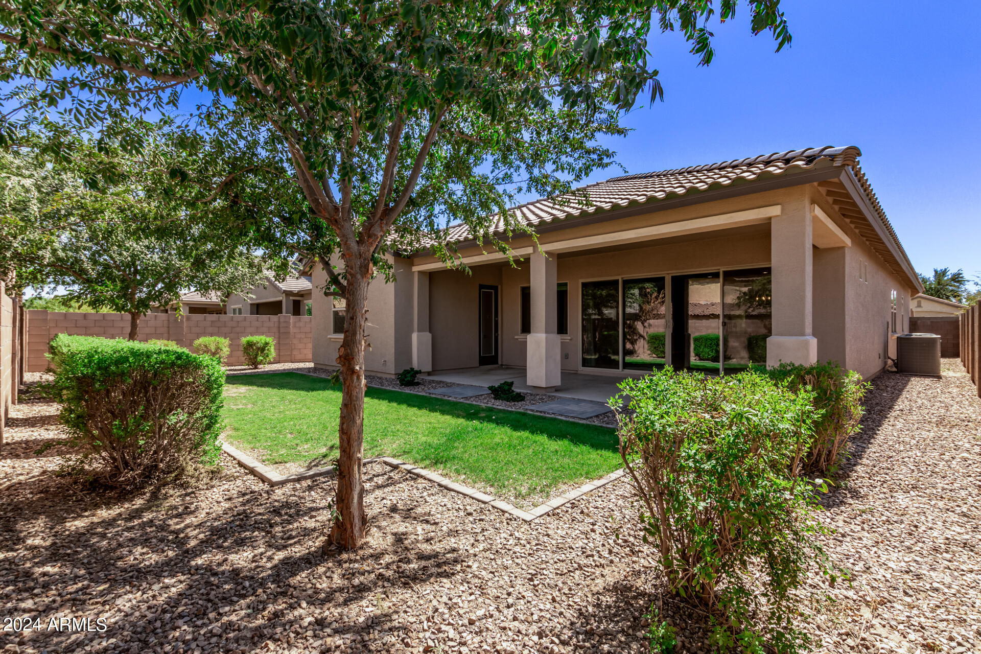 43944 Stonecreek Road Maricopa, AZ 85139 - Photo 47 of 62 a view of a house with brick walls plants and large tree