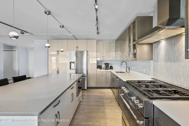a kitchen with stainless steel appliances a sink stove and refrigerator