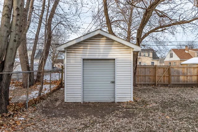 a view of a small house with a fence and a tree