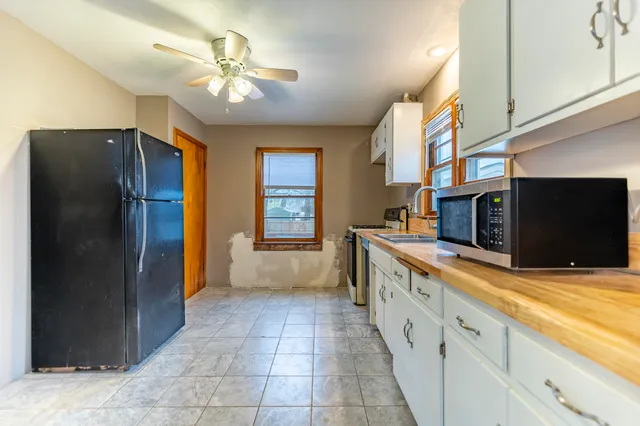 a large kitchen with stainless steel appliances granite countertop a refrigerator and a sink