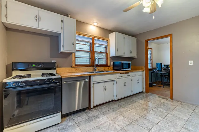 a kitchen with granite countertop a stove top oven sink and cabinets