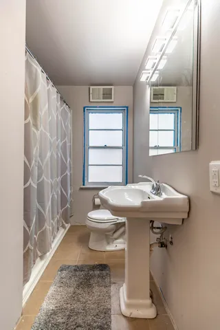 a bathroom with a sink toilet and shower