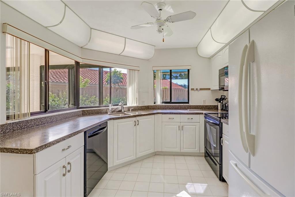 805 Reef Point Circle Naples, FL 34108 - Photo 14 of 33 a kitchen with stainless steel appliances granite countertop a sink and cabinets