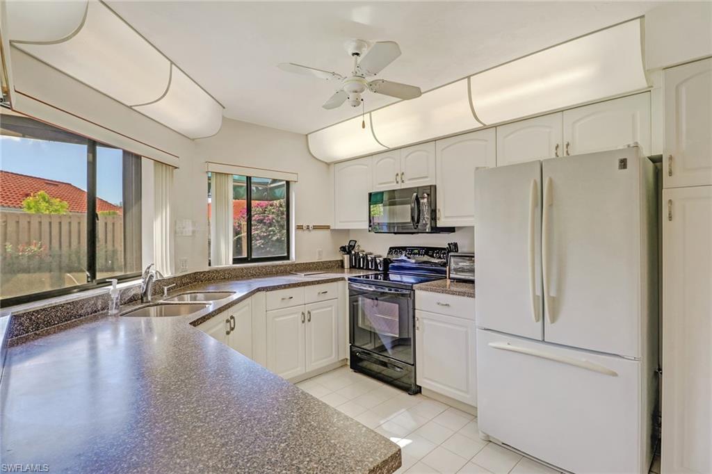 805 Reef Point Circle Naples, FL 34108 - Photo 15 of 33 a kitchen with stainless steel appliances a sink cabinets and a refrigerator