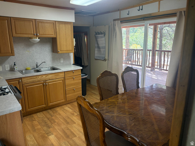 700 West Gravel Road North Kanab, UT 84741 - Photo 54 of 63 Kitchen area featuring wood-finish flooring, wood cabinetry, a double basin stainless steel sink, and light-colored countertops