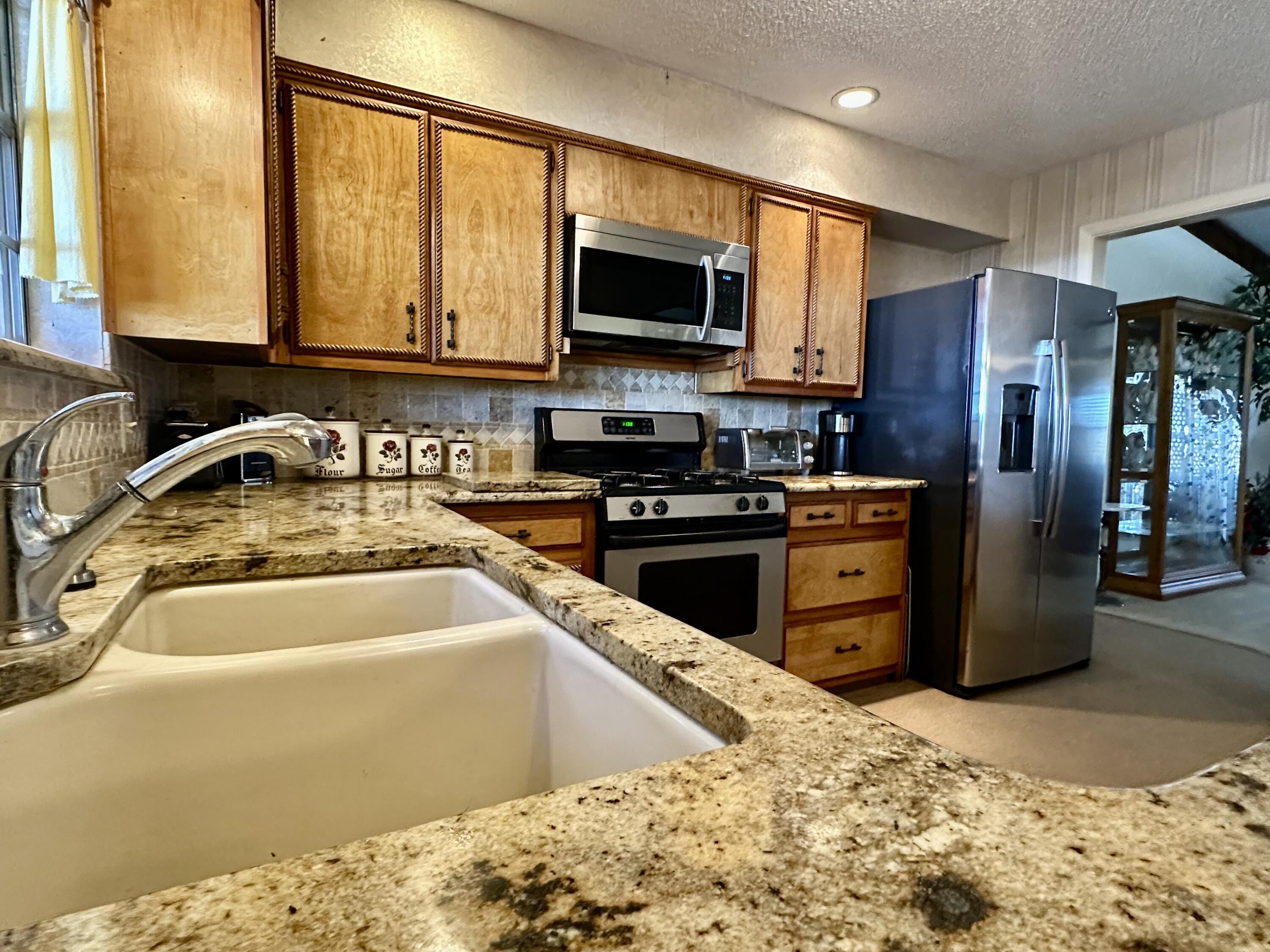 7844 Fm 1318 Tulia, TX 79088 - Photo 20 of 42 a kitchen with stainless steel appliances granite countertop a sink stove and refrigerator