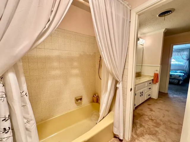 a bedroom with a bed dresser and wooden floor