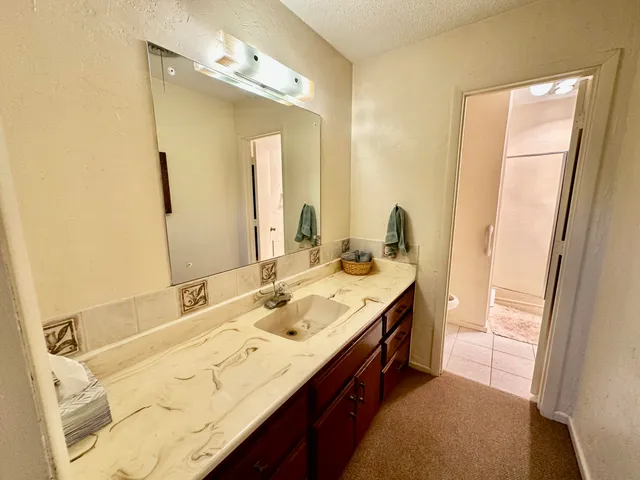 a bathroom with a granite countertop sink and a mirror
