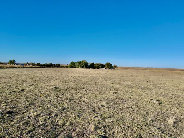 a swimming pool with outdoor seating and yard in back
